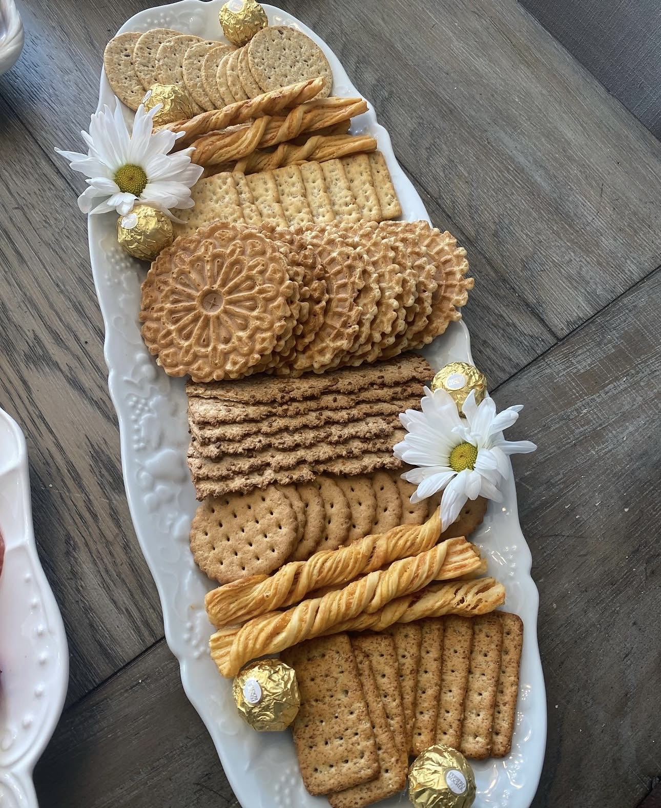 Artisan crackers and cookies platter with daisy flowers